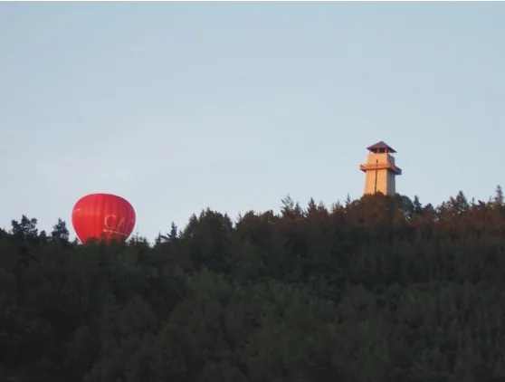 Horkovzdušný balon nad lesem a rozhledna